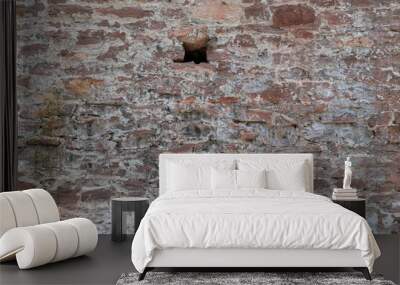 Old stone wall with a hole. Ventilation window concept in an ancient building. Wall mural