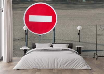 One red no entry traffic sign on the road in the city. The portable sign is mounted on a metal base. Copy space. Wall mural