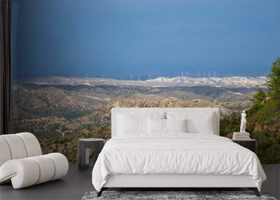 A wind farm is located along a picturesque valley. Wall mural