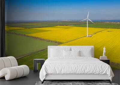 drone view to wind generator between two rapeseed fields under blue sky with copy space Wall mural