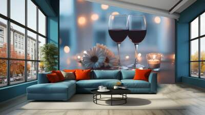 A romantic dinner setting with two glasses of red wine, a bouquet of daisies, and a lit candle on a softly lit table. Wall mural