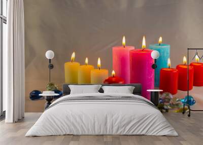 A thin wax candle with a small lit flame with a background. Candles on an old table. Beautiful background. Religious concept. Wall mural