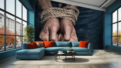 Mens hands tied with a rope, close-up. Concept of imprisonment in modern society Wall mural