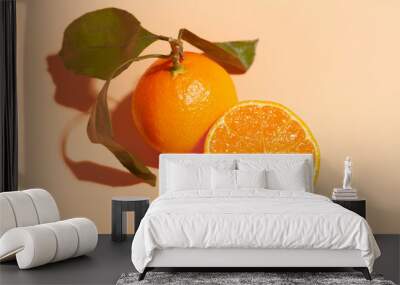 ripe orange tangerine near cutted juicy half mandarin isolated on orange background Wall mural