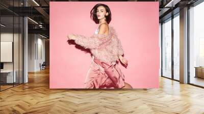 young fashion woman in pink clothes run on pink background Wall mural