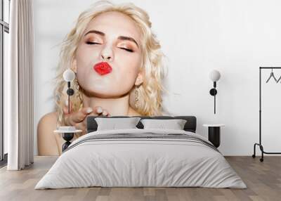 cute young blonde girl with red lipstick blows a kiss, studio fashion photo with copy space Wall mural