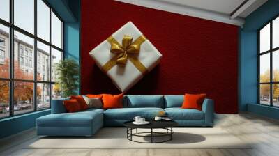 Elegant gift with gold ribbon on red background Wall mural