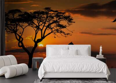 Silhouettes of african wild animals at sunset. Evening in African savanna. Wall mural