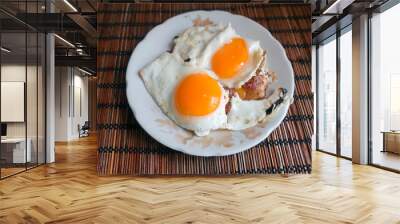 homemade breakfast of fried eggs from two eggs and a piece of fried meat on a plate Wall mural