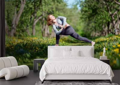 Image of woman with hands to side practicing yoga in forest Wall mural