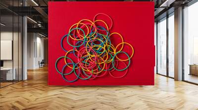 Color rubber bands on red background. Wall mural