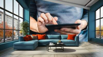 Male hands holding digital tablet and typing message. Concept of businessman using wireless device for work.  Wall mural