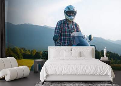 Man motorcyclist ride touring motorcycle in action. Alpine mountains on background. Biker lifestyle, world traveler. Summer sunny sunset day. hermetic packaging bags. Vertical photo. Slovenia Wall mural