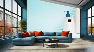 Multiple containers for spray, liquid soap on clean blue background Wall mural