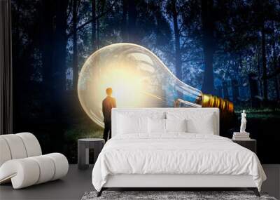 Huge light bulb glowing in the darkness Wall mural