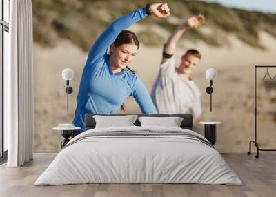 Young couple on beach training together Wall mural