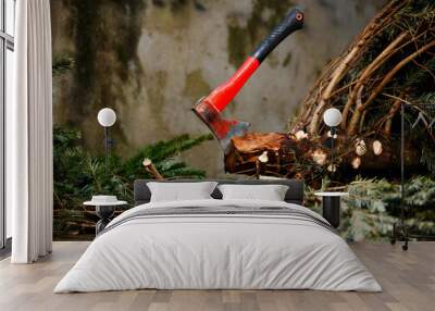 Axe in the Christmas fir tree trunk cut down for celebrations Wall mural