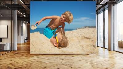 Children's beach day with sand games, digging and burying fun Wall mural