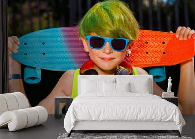 Close-up portrait of a boy with skateboard green hair headphones Wall mural