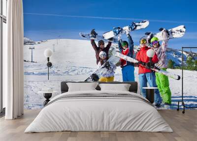 Five snowboarders holding oards and skies together Wall mural