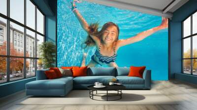 Girl swimming and diving in blue pool with fun Wall mural