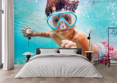 Happy boy in scuba mask swimming underwater Wall mural