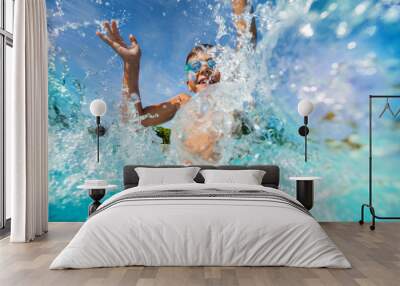 Happy boy playing and splashing in swimming pool Wall mural