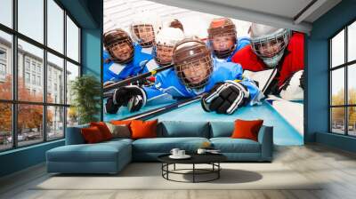 Happy boys in hockey uniform laying on ice rink Wall mural