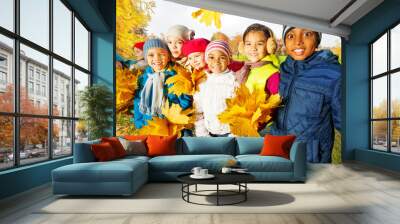 Happy children with bunches of yellow maple leaves Wall mural