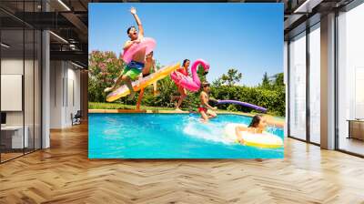 Happy friends jumping in pool on the vacations Wall mural