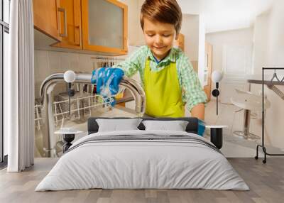 happy kid boy rinsing dishes in the sink Wall mural