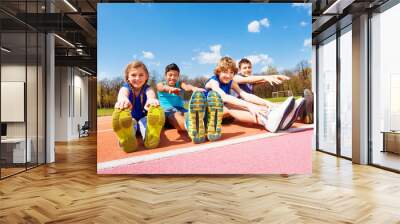 Happy kids doing stretching exercises on a stadium Wall mural