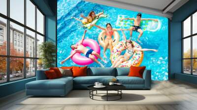 Many happy children friends swim on inflatable ring toys view from above Wall mural