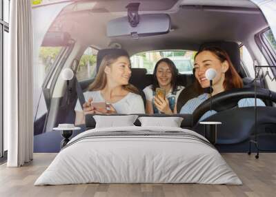 Mother driving a car with her teenage daughters Wall mural