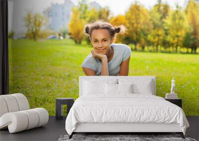 Portrait of African girl sitting on green grass Wall mural