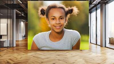 Portrait of beautiful African girl sitting in park Wall mural