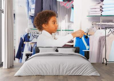 Small African boy in white shirts choosing clothes Wall mural