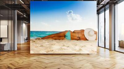 Tanned woman laying on white sand beach Wall mural