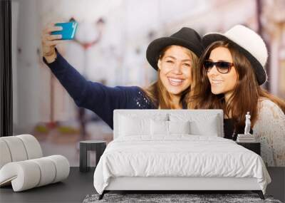 Two cute girls taking selfies with mobile phone Wall mural