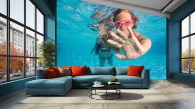 Two little girls diving underwater in pool Wall mural