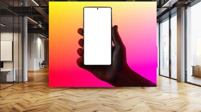 Hand holding phone. Silhouette of male hand holding smartphone isolated on multicolored background. Bezel-less screen is cut with clipping path. Wall mural