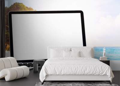 Modern laptop on blue wooden table with blank screen at tropical beach Wall mural