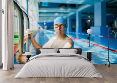 Photo of young swimmer man coming out of indoor pool Wall mural