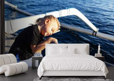 portrait of a cute little girl on a boat at sunrise Wall mural