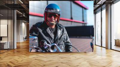 Portrait of a middle-aged man, an old biker in a leather jacket on a retro bike, vintage classic Soviet motorcycle. concept of freedom and style, a hobby for life. copy space, close-up Wall mural