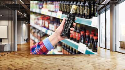 Buyer with soy sauce in store Wall mural