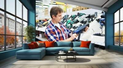 Man shopping for perforator in hardware store Wall mural