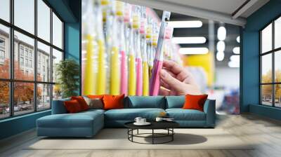 Toothbrush in package in hand in store Wall mural