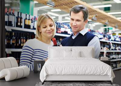 Woman and man selected bottle of wine in store Wall mural