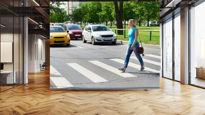 Woman crossing street at pedestrian crossing Wall mural